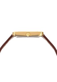 Sidelinje af et slankt guldurehus med en brun læderrem og en rund krone indgraveret med initialerne "CL".