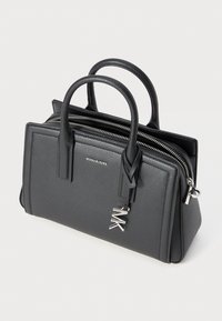 Sac à main en cuir noir texturé avec deux poignées supérieures, quincaillerie en argent et fermeture à glissière. Doté d'un charme logo et d'une forme rectangulaire.
