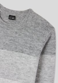 Szary sweter z dzianiny z okrągłym dekoltem, miękką fakturą i gradientowym wzorem przechodzącym od ciemnoszarego do jasnoszarego.