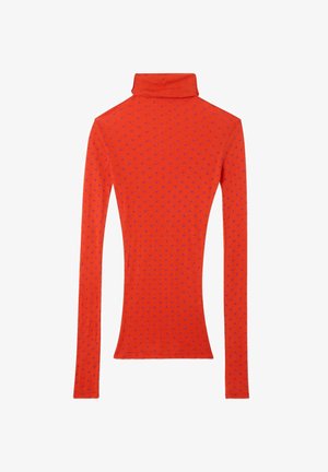 Tievs montējums ar garām piedurknēm un augstu kaklu spilgtā oranžā krāsā ar sīkām purpura punktiņām, izlikts uz plakanas virsmas, ar aizmuguri uz augšu.