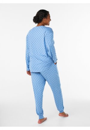 Light blue pajama set with black polka dots, featuring long sleeves and elastic cuffs. Soft fabric with a relaxed design and comfortable fit.