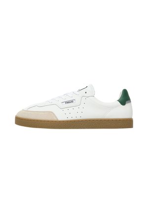 White low-top sneaker with beige suede toe, green heel tab, perforated sides, and brown textured sole, branded with "FAGUO" on the side.