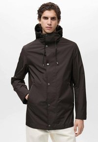Jachetă impermeabilă de culoare maro închis, cu guler înalt, glugă ajustabilă, închidere cu capse și buzunare laterale; textură netedă, design minimalist.