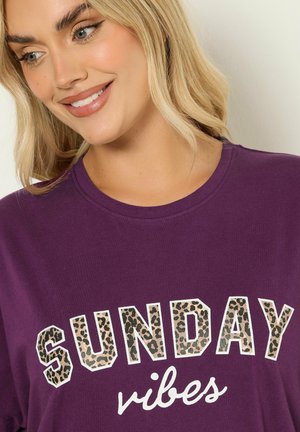 Fioletowa bawełniana koszulka z napisem "SUNDAY" w print leopardzim i "vibes" na biało, okrągły dekolt i krótkie rękawy.