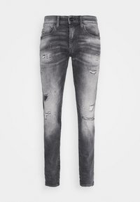 Vervaagde zwarte denim jeans met een slim fit, voorzien van versleten details en rafelige patches aan de voorkant. Vijf-pocket ontwerp met een knoopsluiting.