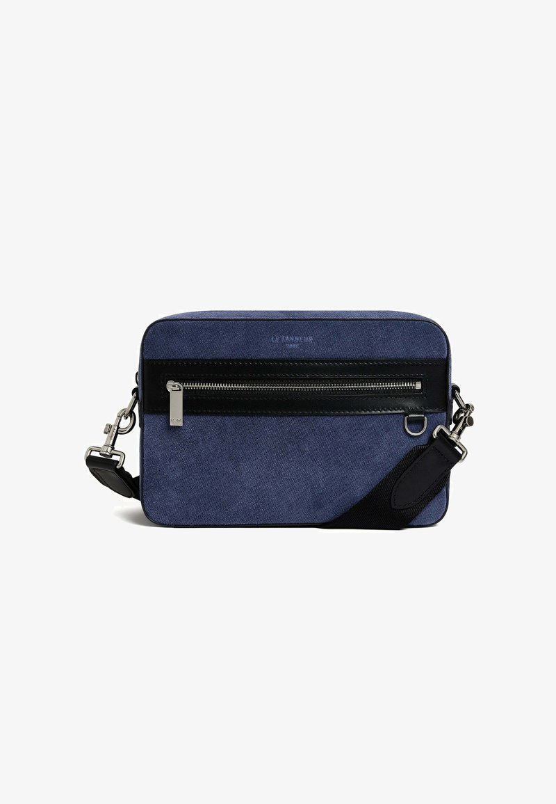 Borsa a spalla in tessuto blu con una tasca con zip in pelle nera, hardware argentato, tracolla regolabile e texture liscia. Presenta una forma rettangolare.