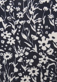 Πυ κνό λευκό λουλουδάτο και φυλλώδες μοτίβο σε υφασμάτινο φόντο με υφή, με διάφορα μικρά και μεγάλα λουλούδια.