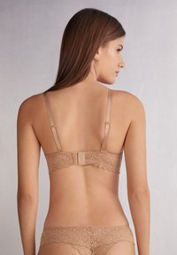 Bralette met beige kant met bloemmotieven, verstelbare bandjes en een haak-en-oogsluiting op de rug. Soepele stofstructuur.