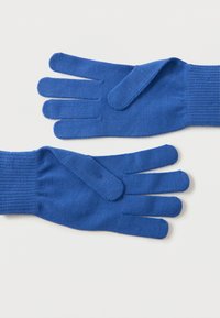 Une paire de gants en tricot bleus avec des sangles de poignet ajustables posés à plat sur un fond blanc.