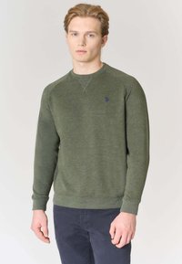 Felpa verde in tessuto strutturato, con scollo rotondo, polsini a coste e un piccolo logo blu sul petto.