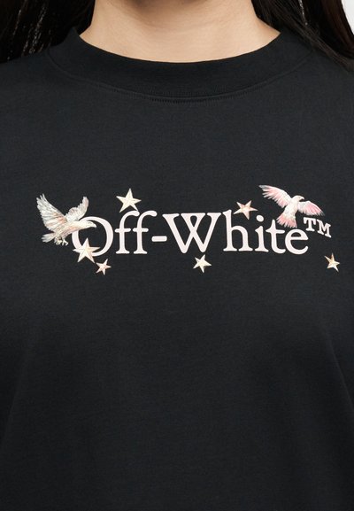 Μαύρο πουκάμισο με λευκό κείμενο "Off-White™", περιβαλλόμενο από μικρά αστέρια και δύο πουλιά με ροζ και λευκά φτερά.