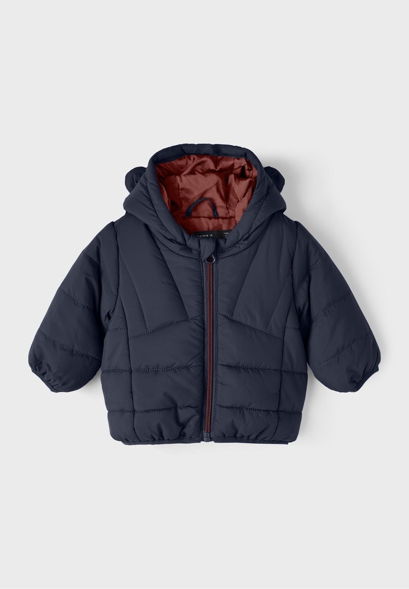 Veste matelassée à capuche en marine, avec un zip sur le devant et une doublure rouge-brun contrastante. Texture douce et poignets élastiques.
