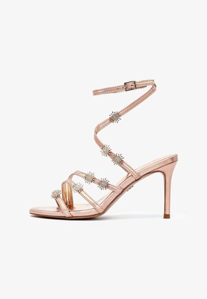 Rose gold high-heeled sandals with a slender strap design, embellished with silver-tone floral accents, featuring a pointed toe and stiletto heel.