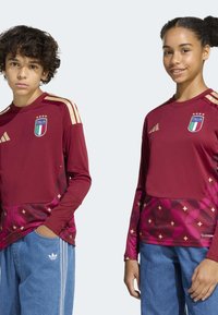 Maroon long-sleeve soccer jerseys with gold accents, featuring the "Italia" badge and a geometric pattern in the lower section.