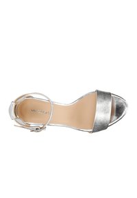 Sandalo con tacco in metallo argentato, dotato di una larga fascia sulle dita dei piedi, cinturino alla caviglia con fibbia e soletta liscia beige.
