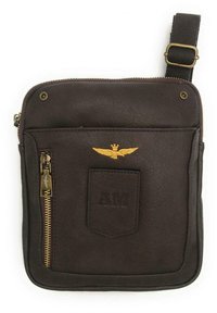 Borse in pelle marrone con chiusura a zip, dotata di tasca frontale, emblema d'oro a forma di ala e logo "AM" impresso. Cinghia regolabile.