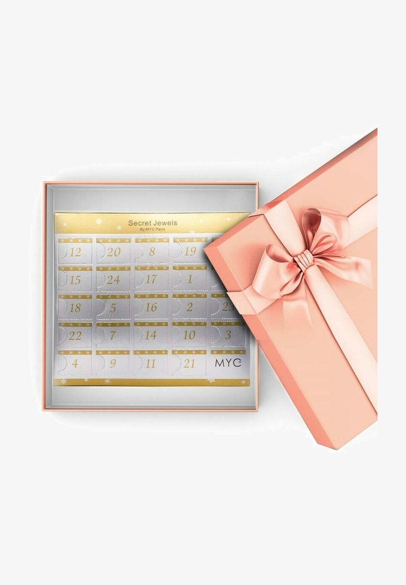 Scatola regalo rosa con un fiocco, aperta per rivelare un calendario argento con accenti dorati e scomparti numerati. Il testo recita "Secret Jewels by MYC Paris."