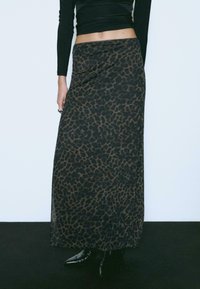 Gonna maxi in una stampa leopardata marrone e nera, realizzata in un tessuto leggero, con una superficie liscia e una vita aderente.
