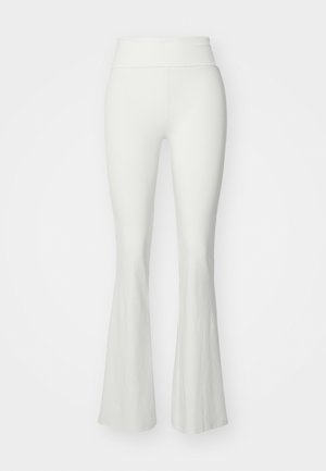 Pantalones blancos acampanados con una cinturilla alta, hechos de un material liso y elástico. Presentan un silueta ajustada que se ensancha en la parte inferior de la pierna.