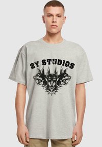 Šedé bavlněné tričko s černou grafikou tří psích hlav a textem "2Y STUDIOS", s kulatým výstřihem a volným střihem.