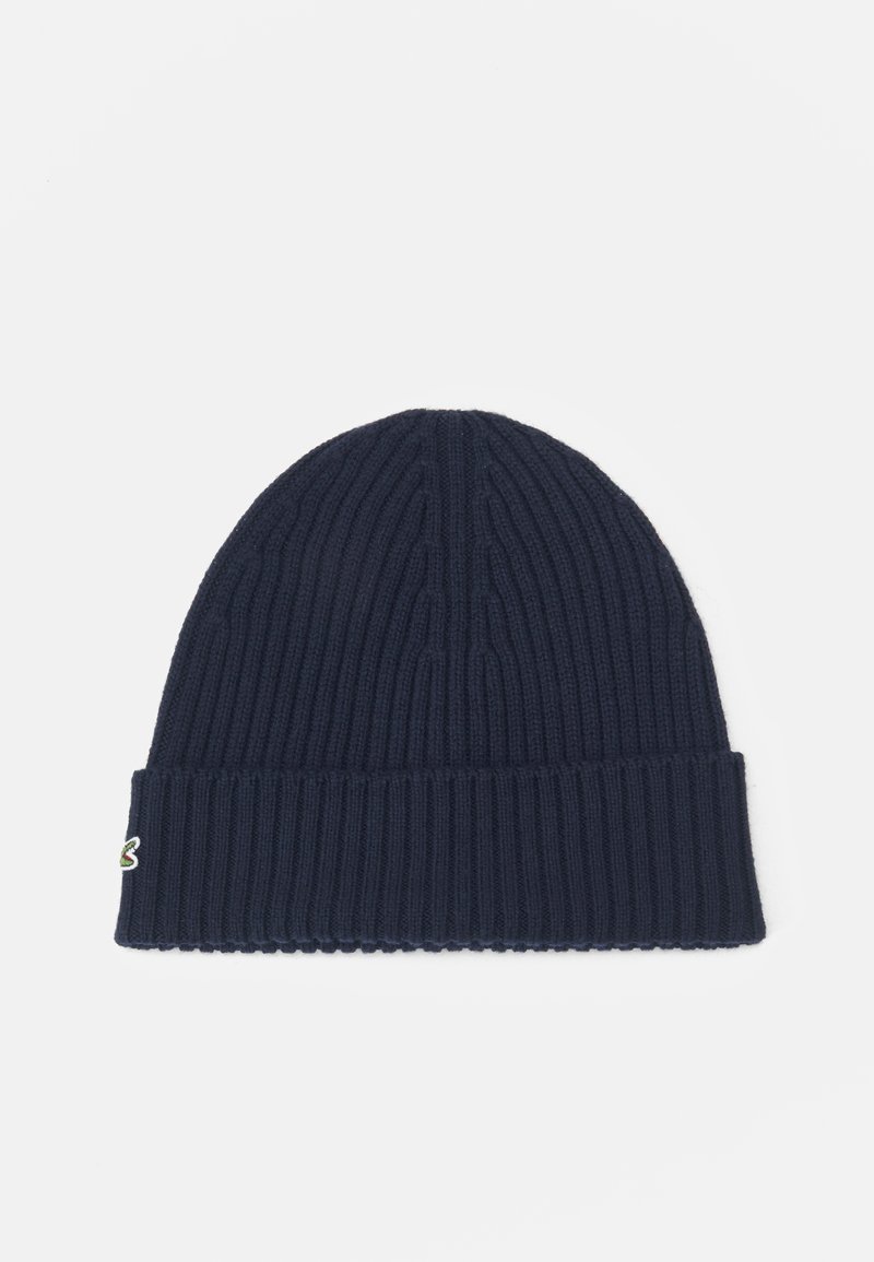 Căciulă tricotată de culoare bleumarin, cu textură ribbată, având un mansetă pliată și un mic detaliu cu logo multicolor pe lateral.