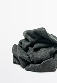 Tissu tricoté gris foncé, froissé en un tas lâche. La texture est douce avec un léger stretch, présentant un motif simple et uniforme.