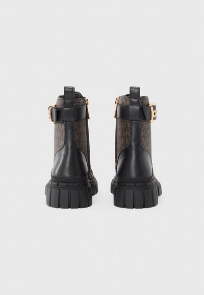 Bottines en cuir noir avec une tige en tissu à motif, accents en métal doré et semelles en caoutchouc épais. Détail de boucle sur le côté inclus.