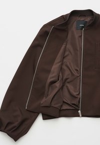 Giacca bomber marrone con fodera interna liscia, colletto a coste e chiusura con zip. Presenta un design elegante e un dettaglio sobrio della tasca.