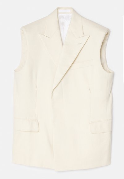 Cremfarbener ärmelloser Blazer aus glattem Material, mit einem spitzen Revers, vorderen Taschen und einer einzelnen dekorativen Nadel.