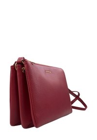 Borsa a tracolla rossa in pelle con finitura testurizzata. Presenta una chiusura con zip e una forma slim e rettangolare. Incluso cinturino regolabile.