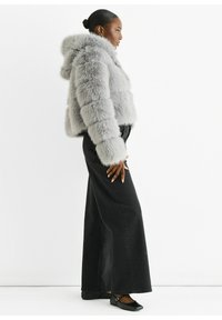 Gray faux fur cropped jacket with a hood, joined by wide-leg black denim pants. The outfit features a smooth texture and tailored shape.