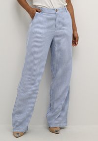 Pantaloni a gamba larga a righe blu e bianche con chiusura a bottone e tasche laterali, realizzati in tessuto leggero. Accentuati da una texture morbida.
