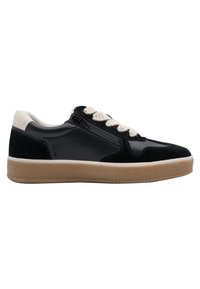 Μαύρο sneaker χαμηλού τύπου με μπεζ σόλα, λευκή λεπτομέρεια στη φτέρνα, κρεμ κορδόνια και πλαϊνό φερμουάρ σε λευκό φόντο.
