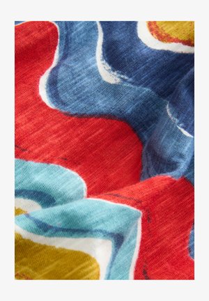 Tessuto multicolore con motivi floreali astratti in rosso, blu e giallo. La texture è morbida, con un aspetto leggermente tessuto.