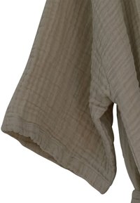 Smėlio spalvos, tekstūruotas audinys, kuris atrodo švelniai susiglamžęs; turi bangelėmis išdėstytą kraštą ir laisvą, prigludusį dizainą, užtikrinantį patogumą ir lengvą dėvėjimą.