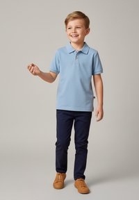 Jasnoniebieska koszulka polo z kołnierzykiem i trzema guzikami, zestawiona z granatowymi spodniami i beżowymi trampkami. Gładka tkanina, casualowy krój.