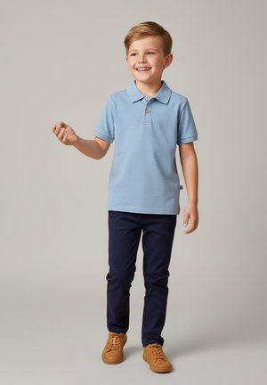 Jasnoniebieska koszulka polo z kołnierzykiem i trzema guzikami, zestawiona z granatowymi spodniami i beżowymi trampkami. Gładka tkanina, casualowy krój.