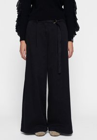 Zwarte wijde broek met riemlussen, een bijpassende stoffen riem en een gladde textuur. Beschikt over een op maat gemaakte, hoge taille.