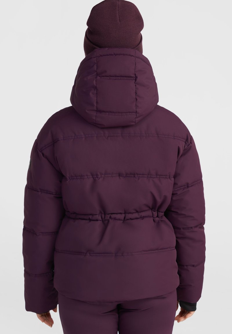 Lila gepolsterte Jacke mit Kapuze, mit horizontalen Nähten, einem elastischen Bund und einer passenden Strickmütze oben drauf.