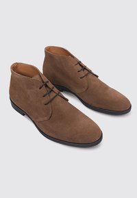 Bottines en daim marron avec une finition lisse, un design à lacets et des semelles en caoutchouc noir. Bout rond et détails de couture minimaux.