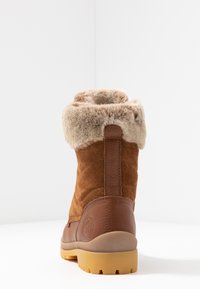 Brune semsket ankelstøvel med kunstig pelskant, strukturert overdel, buet design, gummisåle og baklogo.