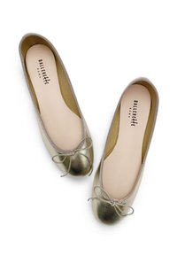 Ballerine in pelle metallizzata dorata con punta arrotondata, un sottile fiocco nella parte anteriore e una morbida fodera interna beige.