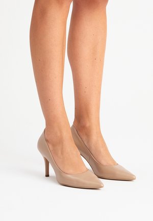 Béžové kožené lodičky s špičatou špičkou a 3 palcovým jehlovým podpatkem. Hladká textura, minimalistický design bez viditelných ozdob.