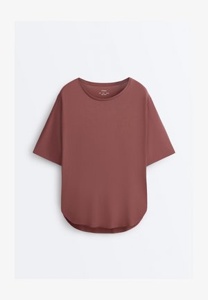 Tricou mov pal cu mâneci scurte și decolteu rotund, cu tiv curbat, prezentat pe un fundal alb simplu.