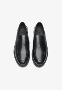 Schwarze Lederloafers mit glatter Textur, runder Zehenpartie und genähten Details entlang der Sohle. Verfügt über ein breites, dekoratives Band über dem oberen Teil.