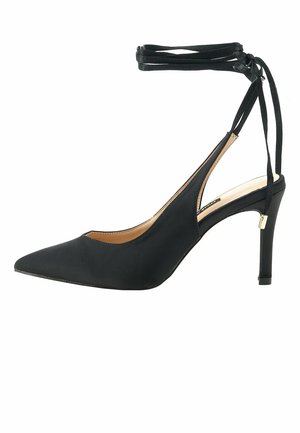 Escarpin noir à bout pointu avec des brides à la cheville et un talon aiguille fin.