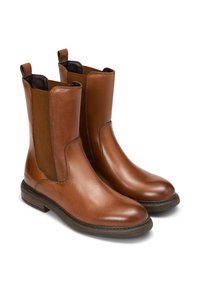 Bottines en cuir marron avec des panneaux latéraux élastiques, une finition lisse et une semelle en caoutchouc texturée basse. Deux tirettes pour un enfilage facile.