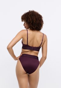 Sutien burgundy Calvin Klein și chilot înalt asortat, realizat dintr-un material neted, cu bretele ajustabile și talie elastică, cu accente de logo.