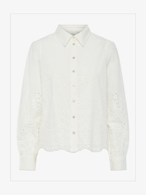 Weiße Bluse mit langen Ärmeln und Knopfverschluss an der Vorderseite, mit floralem Ajour-Stickereien und gewelltem Saum. Weicher Baumwollstoff und strukturierter Kragen.