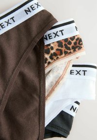 Fyra par underkläder har en brun enfärgad, en leopardmönstrad, ett ljust mönster och en svart, med vita elastiska band märkta "NEXT."